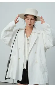 Vue détaillée d'un trench-coat blanc à double boutonnage stylisé avec chapeau et sac