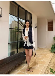 Gilet en jean bleu foncé vintage avec coutures contrastées et chemisier blanc