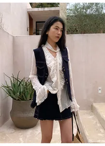 Vue détaillée du gilet en jean rétro avec coutures contrastées sur mannequin asiatique