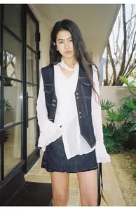 Gilet en jean bleu foncé vintage avec coutures contrastées et boutons dorés.