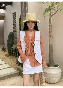 Détail d'un gilet en jean rétro blanc avec surpiqûres contrastées pour femme