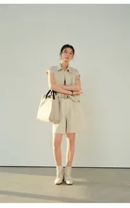 Full-length view of beige linen wide-leg shorts styled with a matching vest and tote bag.