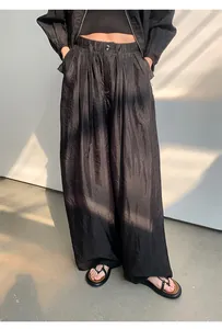 Detailansicht der schwarzen Hose mit weitem Bein, Crinkle-Struktur und lockerem Fall.