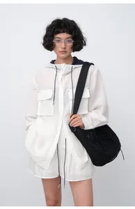 Woman wearing lightweight Tencel ramie hooded shirt and shorts set with black mesh bag
