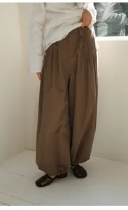 Detailed shot of women's vintage brown checkered wide-leg trousers in a relaxed fit