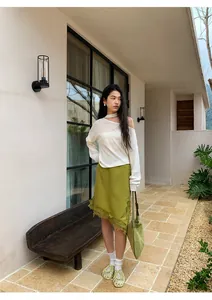 Detalle de cuerpo entero de falda midi verde oliva irregular con ribete de encaje exterior
