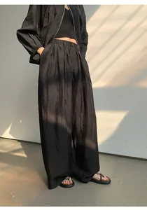 Detailansicht der schwarzen Damen-Hose mit weitem Bein, elastischem Bund und Faltenwurf