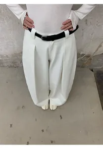 Vue détaillée d'un jean blanc à jambes larges pour femme avec une ceinture noire