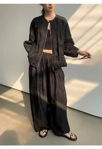 Detailansicht einer schwarzen weiten Hose mit hochwertiger Textur und elastischem Bund