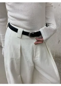 Vue détaillée d'un jean blanc à jambes larges avec ceinture tressée noire et texture