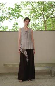 Detailweergave van donkerbruine wijde broek voor dames met een elegant sjaalaccent.