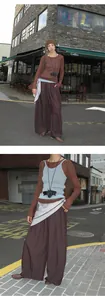 Detailed view of women's loose brown wide-leg pants styled with a printed silk scarf accessory