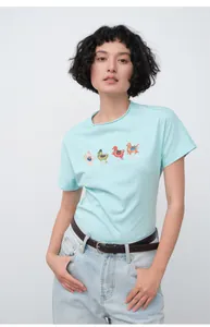 Femme élégante portant un jean droit bleu clair et un T-shirt avec des illustrations