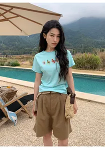 Casual women's linen wide-leg shorts with woven belt shown in outdoor poolside setting
