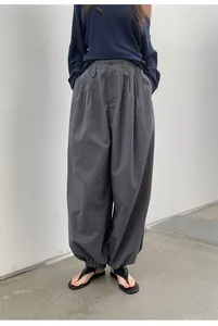 Detail view of retro plaid loose-fit trousers with elastic hem and high waist.