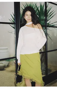 Vista detallada de una falda asimétrica verde lima con encaje en una modelo femenina.