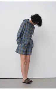 Side view of model wearing blue and green plaid lightweight hooded shirt and shorts set