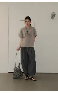 Full view of retro checkered loose casual pants paired with a grey graphic tee