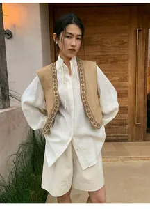 Model wearing white linen wide-leg shorts with a bohemian vest outdoors.
