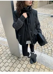 Fashionable woman wearing black thermal yoga leggings with boots in urban street setting