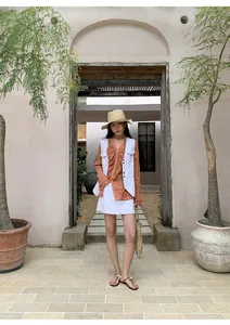 Photo extérieure d'une femme portant un gilet en jean blanc à surpiqûres contrastées