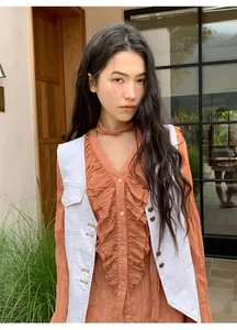 Mannequin portant un gilet en jean blanc vintage avec surpiqûres sur une robe à volants
