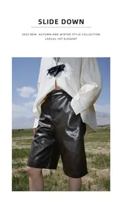 Close-up detail of black PU leather wide-leg shorts styled in an outdoor setting