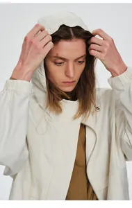 Gros plan d'un coupe-vent d'extérieur blanc pour femmes avec une capuche au design fonctionnel.