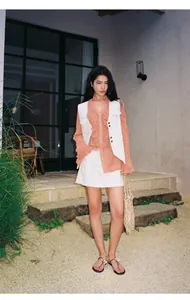 Gilet en jean blanc rétro à coutures contrastées porté avec un chemisier rose