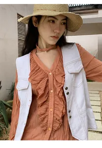 Détail du gilet en jean vintage blanc avec coutures contrastées et poches décoratives.
