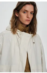 Détail rapproché du coupe-vent d'extérieur blanc pour femme avec capuche
