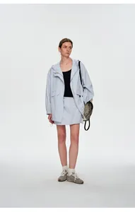 Vue complète d'une femme en veste coupe-vent d'extérieur lilas et jupe assortie.