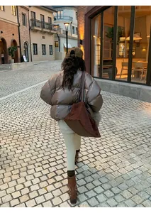 Woman in beige thermal yoga leggings and puffer jacket styled on a winter street