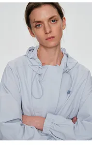 Détail d'une veste de plein air bleu clair pour femme avec capuche réglable