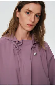 Détail en gros plan d'une veste coupe-vent violette imperméable avec capuche pour femmes