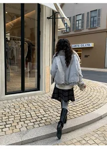 Street style view of women's warm gray yoga leggings with a plaid skirt and boots