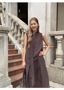 Detail view of the brown irregular pleated skirt set worn by a model in an outdoor setting.