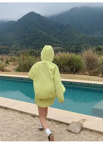 Achteraanzicht van limegroen sportief outdoor jack met capuchon en mini-rok met koord