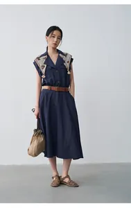 Model wearing a navy blue sleeveless A-line dress with scarf collar and belt detail