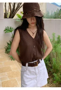 Detail shot of a vintage brown mesh knit vest worn by a model in an outdoor setting