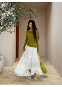 Full view of elegant white tiered maxi skirt with irregular hem and elastic waist.