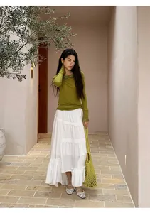 Elegant white tiered maxi skirt with irregular hem shown in an outdoor lifestyle setting