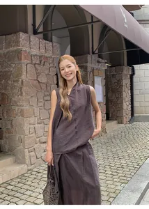 Fashionable Asian model wearing a coffee brown irregular pleated skirt set in a street scene