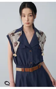 Close-up of navy sleeveless dress featuring horse print scarf detail and leather belt
