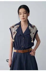 Elegant navy blue sleeveless dress with lapel scarf detail and a brown woven belt