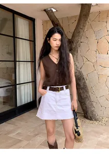 Detailed view of women's brown V-neck mesh knit vest in a chic outdoor setting