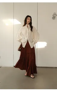 Detailed full-body look of a brown irregular tiered cake skirt with a white blouse.