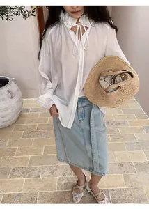 Elegant woman wearing light blue straight denim midi skirt and white ruffled blouse