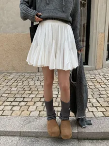 Detalle de una falda corta plisada blanca con una cómoda cintura elástica ajustable.