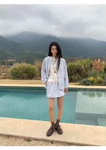 Model met lichtblauwe outdoor rok met trekkoord bij een zwembad in de bergen